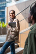 © Jovo Jovanovic/Stocksy - Smiling woman in hijab with tablet meets friend outside.