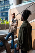 © Jovo Jovanovic/Stocksy - Two young adults meet on stairs outside a building.