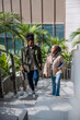 © Jovo Jovanovic/Stocksy - Two young professionals walk up stairs outside an office building.
