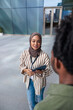 © Jovo Jovanovic/Stocksy - Woman in hijab with tablet talking to colleague.