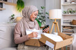 © Jovo Jovanovic/Stocksy - Woman smiles while opening a gift