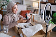 © Jovo Jovanovic/Stocksy - Young Muslim woman live streams unboxing
