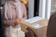 © Jovo Jovanovic/Stocksy - Delivery person about to hand package to customer