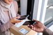 © Jovo Jovanovic/Stocksy - Contactless delivery: Woman scans to confirm receipt