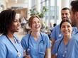 © Meow Creations - Cheerful diverse group of nurses standing together and laughing in a bright hospital corridor