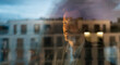 © Artcore Studio/Stocksy - Man reflecting, looking out city window at sunset