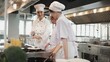 © tigercat_lpg - Female chef demonstrates to intern student girls, cooking class in catering restaurant kitchen, professional gourmet master in delicious cuisine, ingredients preparation in eatery, and culinary meals.