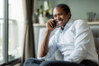 © Maia Images/Stocksy - Smiling Businessman On Phone In Modern Home Office