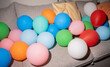 © Luis Velasco/Stocksy - Colorful Balloons Scattered on a Cozy Sofa in a Lively Room