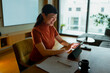 © Artcore Studio/Stocksy - Asian woman working from home using digital tablet