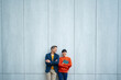 © Artcore Studio/Stocksy - Business colleagues standing against modern blue wall outdoors