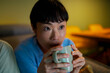 © Artcore Studio/Stocksy - Woman intently watching television show while drinking hot beverage