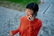 © Artcore Studio/Stocksy - Asian woman smiling talking on phone outdoors happily