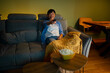 © Artcore Studio/Stocksy - Woman watching tv at home with popcorn
