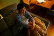© Artcore Studio/Stocksy - Asian woman relaxing on sofa watching evening entertainment