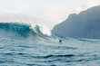 © Adrian Rodd/Stocksy - Panoramic seascape showing a huge wave with a surfer in the distance