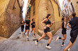 © Javier Díez/Stocksy - Group of runners sharing a lively moment in a narrow street