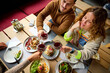 © Ivan Jovanovic/Stocksy - Group of friends celebrating in a restaurant