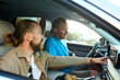 © Ivan Jovanovic/Stocksy - Two men drive in a car.