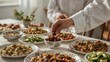 © Creative_johirul - A person serving dates at a table with various dishes