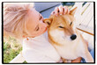 © Olly R/Stocksy - Film closeup portrait of a woman tenderly stroking her Shiba Inu dog