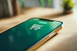 © Людмила Мазур - A close up view of a modern smartphone displaying a shopping cart icon on its screen, resting on a clean white surface.