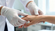 © INSPIRIA.K - Close-up of doctor's hands in white gloves examining patient's wrist and fingers. Diagnostic of rheumatoid arthritis or joint swelling.