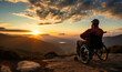 © ink drop - silhouette of a person in a wheelchair on top of a mountain