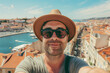 © ink drop - A man taking a selfie with a smartphone on a european city adventure break