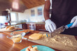© Wavebreak Media - African American man in apron shredding cheese in home kitchen with blue grater, copy space