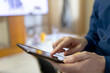 © Wavebreak Media - African American male holding tablet and tapping touchscreen in office lounge near monitor