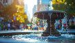 © hardvicore - City water fountain with blurred urban background, street scene, soft bokeh, daytime lighting.