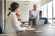 © Jelena - Mature businesswoman leading business meeting discussing strategy