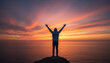 © mirukser - Person Silhouetted Against Sunset Sky, Arms Raised in Triumph by the Ocean