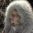 © Valeriia - Winter portrait of young woman in white fur hood coat outdoors at night, cold weather fashion and cozy seasonal style