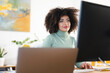 © Studio Marmellata - A woman with curly hair works on her computer in a bright office. She is focused on her screen, typing on a keyboard.