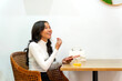 © Alfonso Soler - Latina businesswoman smiling in cafe holding smartphone