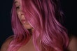 © Марина Демешко - Young woman with vibrant pink hair, smooth texture and soft shine on a dark background. Beauty portrait focused on color, hair care, femininity and modern self expression