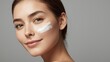 © LimeSky - Attractive young woman with facial cream on gray backdrop, close-up