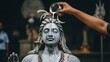 © TheseusStock - A hand pours milk over a detailed stone statue of Lord Shiva during a traditional Hindu religious ritual, symbolizing devotion and purity.