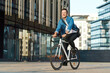 © muse studio - Cyclist rides bike in urban area with modern buildings
