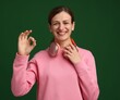 © New Africa - Happy woman with headphones showing okay gesture on green background