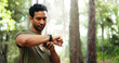 © peopleimages.com - Fitness, athlete and man with smart watch, outdoor and workout progress on app, space and heart rate. Park, runner and person with technology for exercise update, break or health monitoring in nature