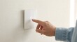© Dreamscape - Man touching smart light switch on modern wall,gesture control home automation concept,illuminated icon interface for energy saving and smart house lighting system
