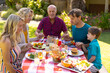 © wavebreak3 - Caucasian three generational family praying before eating lunch in the garden