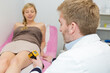 © auremar - doctor performing electronic treatment to womans leg