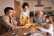 © Jelena - Multi-generational family enjoying a holiday lunch together