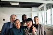 © Marko Geber - Adult and senior team smiling together in modern office