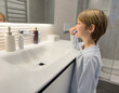 © Danko - Child boy brushing his teeth in the toilet. Dental care.