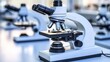 © Trisna - Microscope in lab, focused lens with other blurred microscopes in background